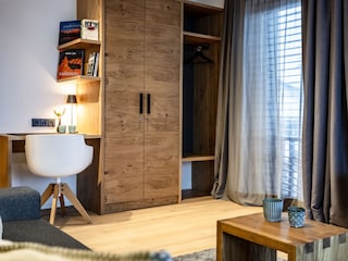 Wohnzimmer mit Schreibtisch und Kleiderschrank