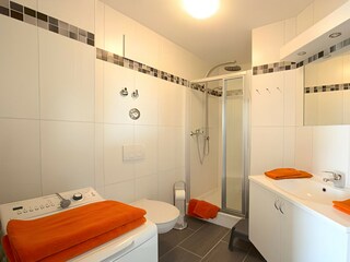 Duschbad mit WC und Waschmaschine.