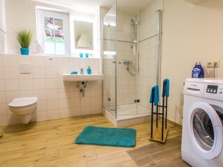 Badezimmer mit Dusche und Waschmaschine