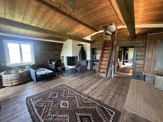 Die Stube verfügt über eine große, offene Feuerstelle