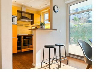 Wohnzimmer mit Küche und Zugang zum Balkon