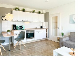Wohnzimmer mit Essbereich und Küchenzeile
