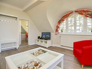 Wohnzimmer mit Sessel und Bogenfenster