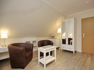 Wohnzimmer mit Sitzgruppe und Kleiderschrank
