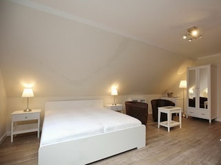 Wohnzimmer mit Doppelbett und Schrank