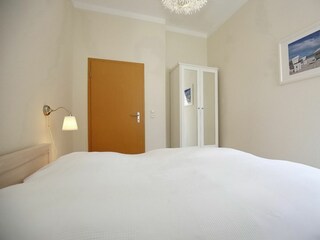 Schlafzimmer mit Doppelbett und Kleiderschrank