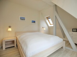 erstes Schlafzimmer mit Doppelbett und Komode