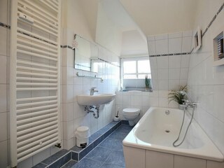Badezimmer mit Badewanne und WC
