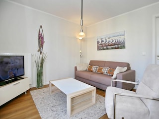 Wohnzimmer mit Schlafcouch und TV