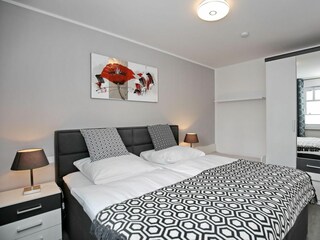 Schlafzimmer mit Doppelbett und Kleiderschrank