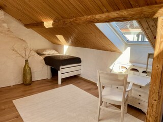 Einzelbett neben dem urigen Kamin