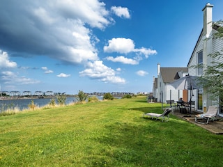 riesige Rasenfläche zwischen Meer und Ferienhaus