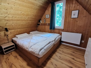 Doppelbett im zweiten Schlafzimmer im Dachgeschoss