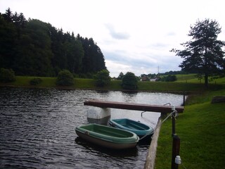 Ruderboote auf dem See mit Steg im Hintergrund