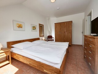 Schlafzimmer mit Doppelbett und TV