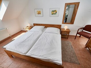 Schlafzimmer mit Doppelbett und TV