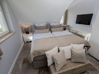 1. Schlafzimmer mit Doppelbett und TV