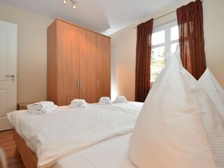 Schlafzimmer mit Doppelbett und Kleiderschrank