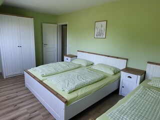 Schlafzimmer mit Doppelbett und einem Einzelbett
