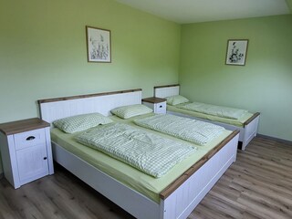 Schlafzimmer mit Doppelbett und einem Einzelbett
