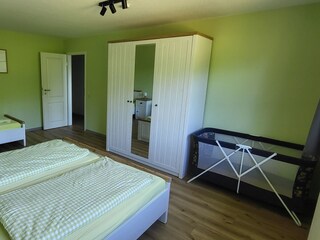 Schlafzimmer mit Doppelbett, Einzelbett und Kinderbett