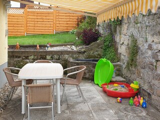 Terrasse mit kleinem Teich und Markise