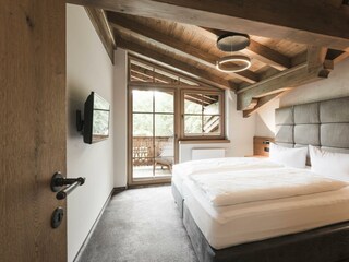 Schlafzimmer mit Sichdachstuhl mit Bergblick