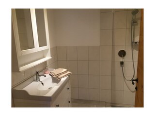 Badezimmer mit Dusche und Waschbecken