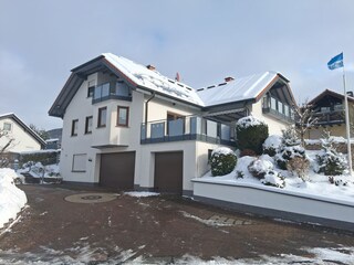 Schneeansicht mit Gästeparkplatz im Hof