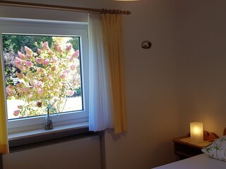 Schlafzimmer mit Blick in den herbstlichen Garten