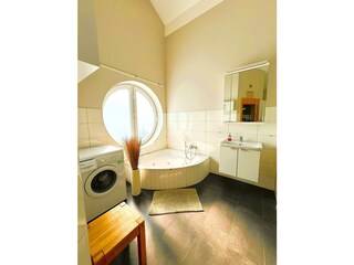 Badezimmer mit Whirlwanne und Waschmaschine