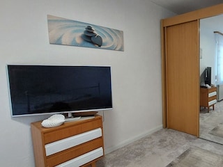 Schlafzimmer 2 mit Fernseher und Kleiderschrank
