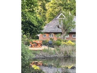 Haus mit Holzterrasse am See oder Teich