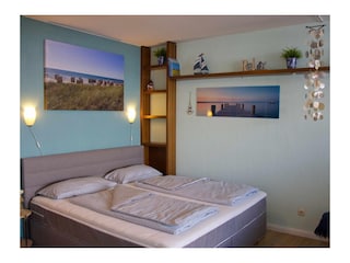 Bequemes Doppelbett im Wohnzimmer der Ferienwohnung Inselblume 83