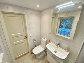 modernes Badezimmer mit WC, Waschmaschine und Dusche