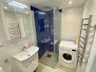 modernes Badezimmer mit WC, Waschmaschine und Dusche