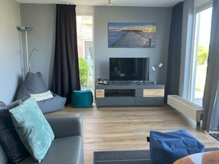 Wohnzimmer mit Sitzsack und Fußhockern, TV, Spiele etc