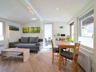 Wohnzimmer mit Couch und Esstisch