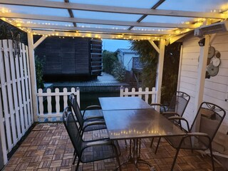 überdachte Terrasse am Abend, davor direkt der Steg