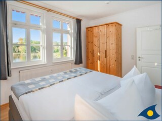 Schlafzimmer 1 mit Doppelbett und Blick auf den Schloonsee