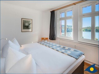 Schlafzimmer 1 mit Doppelbett und Blick auf den Schloonsee