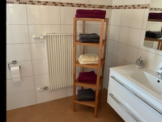 Bad, Waschbecken, Regal mit Hand- und Duschtüchern