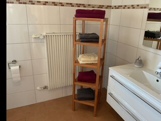 Bad, Waschbecken, Regal mit Hand- und Duschtüchern