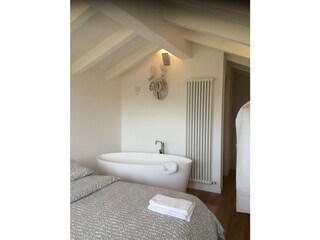 Bedroom with double bed and bathtub