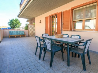 Terasse mit Tisch und Stühlen.