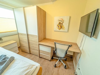 Einzelbett-Schlafzimmer im ersten OG mit Schreibtisch und Fernseher