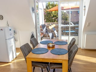 Gemütliches und helles Wohnzimmer mit integriertem Essbereich und schicker Küchenzeile