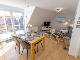 Gemütliches und helles Wohnzimmer mit integriertem Essbereich und schicker Küchenzeile