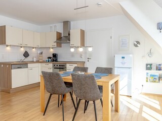 Gemütliches und helles Wohnzimmer mit integriertem Essbereich und schicker Küchenzeile