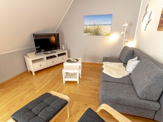 Gemütliches und helles Wohnzimmer mit integriertem Essbereich und schicker Küchenzeile